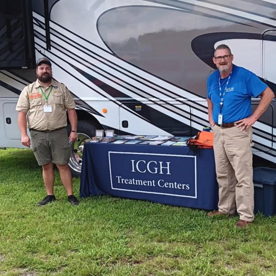 ICGH and community partner beside an outreach table
